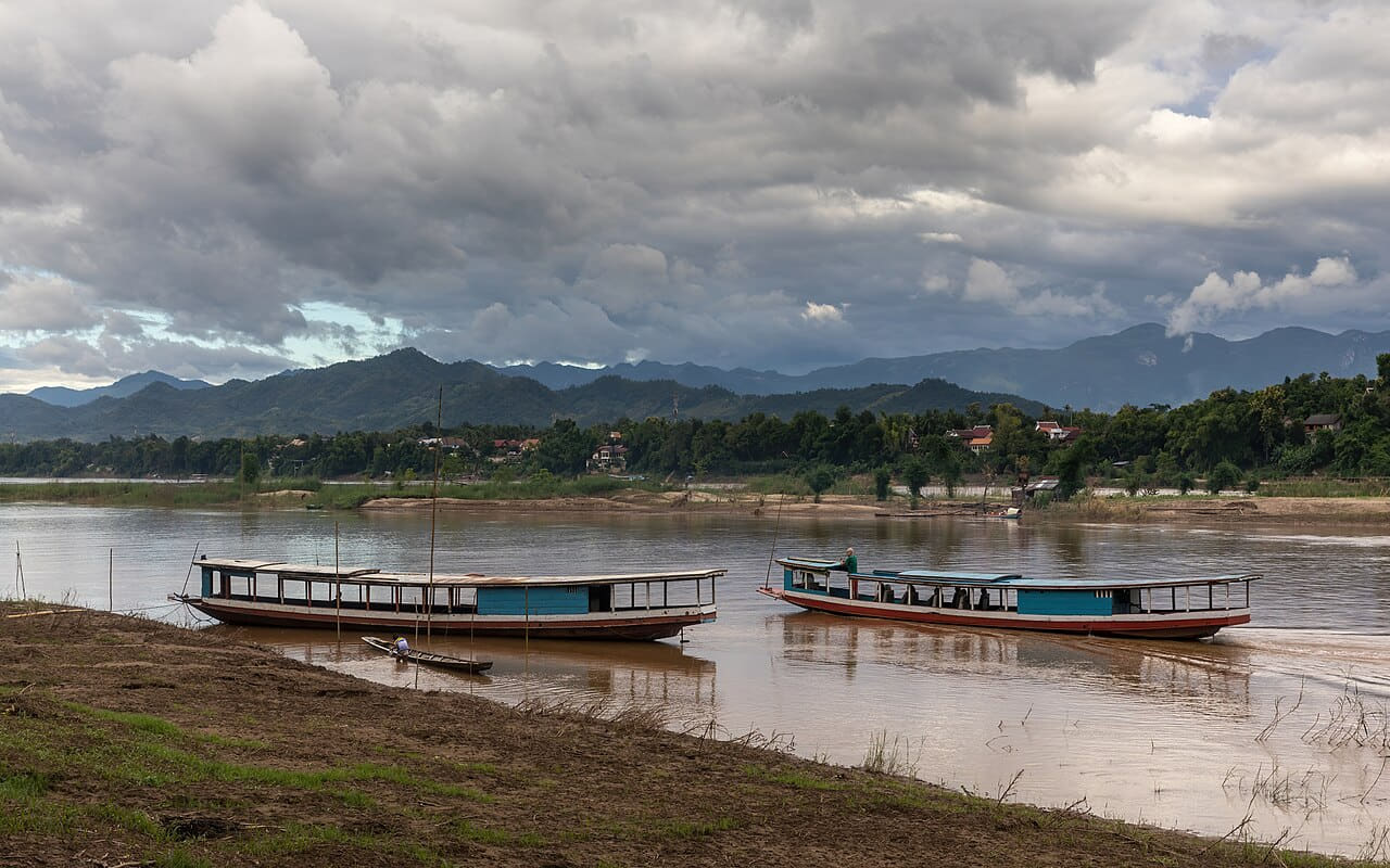 Boats on the Mekong with dark clouds and blue sky… wallpaper in sage green and sand tones, Full HD, 16:9 format for phone